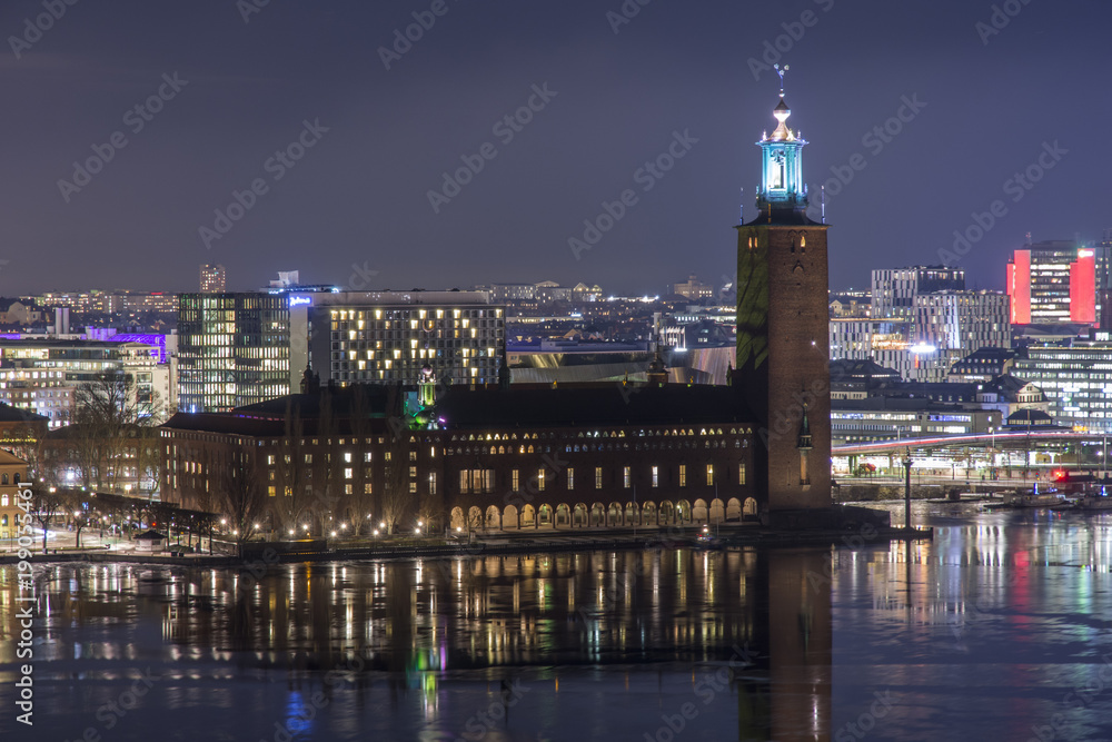 Stockholms Stadshus Tre kronor fotat en klar natt med Stockholms city i bakgrunden till höger