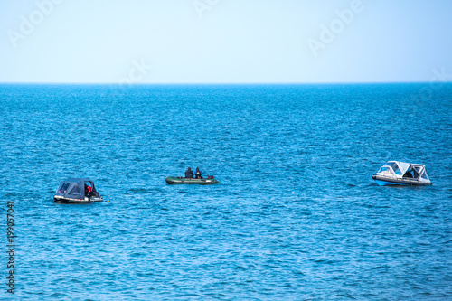 divers in rubber boats in the blue sea © Sergey