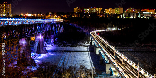 coloured lights illuminating brides crossing a frozen river at night