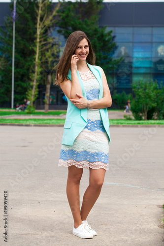 Beautiful brunette woman in summer dress on the street © Andrey_Arkusha