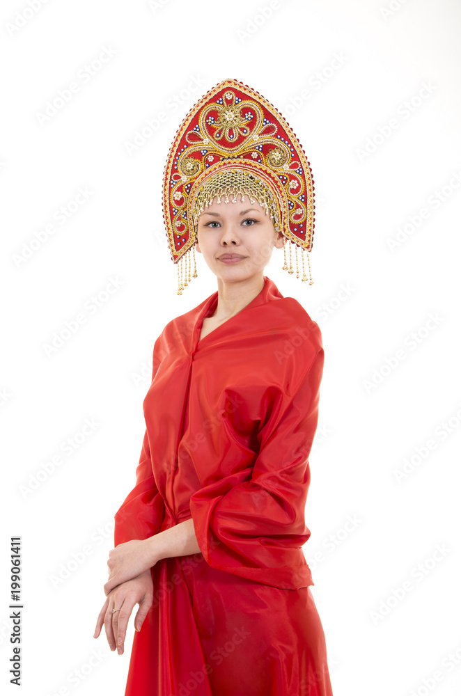 Portrait of smiling girl in kokoshnik (headdress) and red dress on white background.