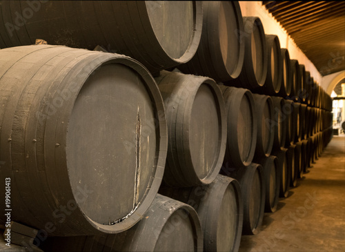 Row of stacked wooden wine barrels for sherry aging