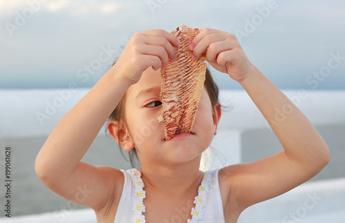 Adorable little girl eating Mashed squid. 