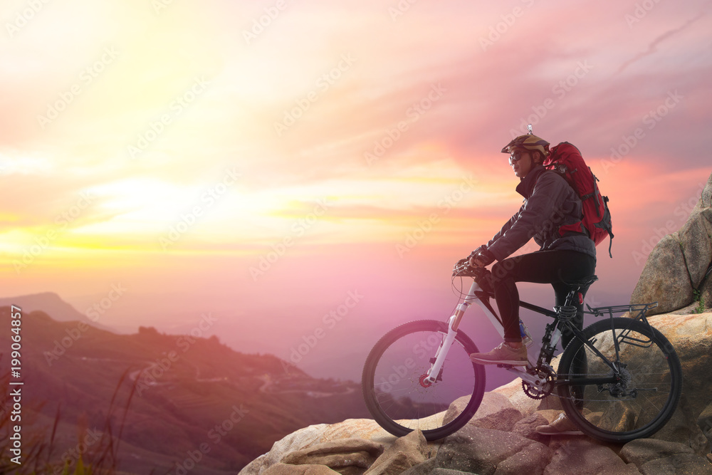 Fototapeta premium Biker riding on bicycle in mountains cyclist on the top of a hill