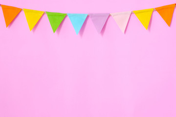 Colorful party flags hanging on pink background, birthday, anniversary, celebrate event, festival greeting card background