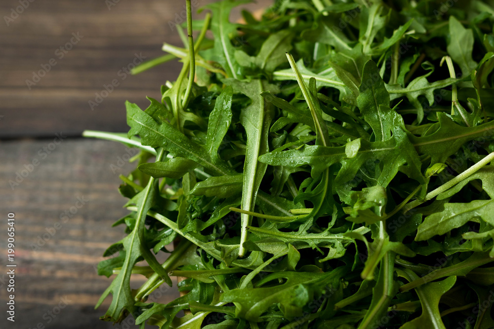 Fresh rucola with water droplets on a dark rustic background Fresh rucola with water droplets on a dark rustic background