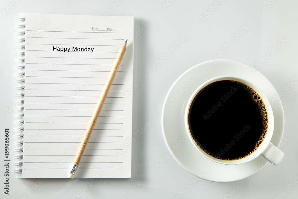 White cup of coffee morning on wooden table with notebook White cup of coffee morning on wooden table with notebook
