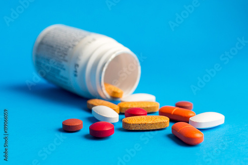 Assorted pharmaceutical medicine pills on blue background