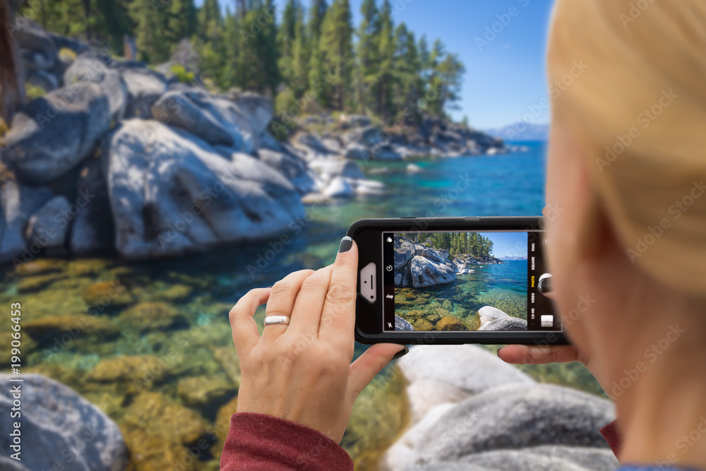 Woman Taking A Beautiful Lake Picture with Her Smart Phone Woman Taking A Beautiful Lake Picture with Her Smart Phone