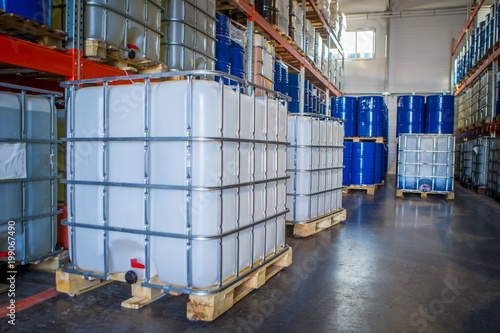 White plastic barrel. Barrel on a pallet with a metal frame. Shipment of chemicals. Plastic container for liquids.