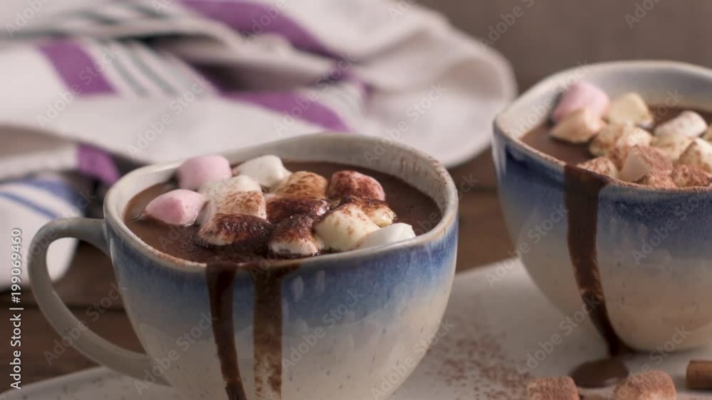 Cups of hot chocolate drink with marshmallows and cinnamon on brown wooden background. Cups of hot chocolate drink with marshmallows and cinnamon on brown wooden background.