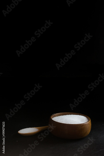 Salt in Cup made of wood with spoon  isolate on Black background  