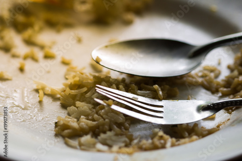 Close-up fork and spoon on an empty dirty white plate with copy space