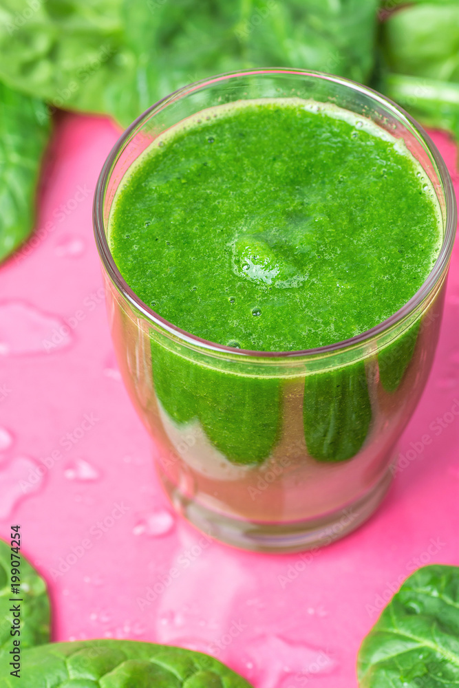 Glass with Green Fresh Smoothie from Leafy Greens Vegetables Fruits. Apples Bananas Kiwi Zucchini Scattered Spinach Leaves on Fuchsia Pink Background with Water Drops. Healthy Lifestyle Detox Vitamins Glass with Green Fresh Smoothie from Leafy Greens Vegetables Fruits. Apples Bananas Kiwi Zucchini Scattered Spinach Leaves on Fuchsia Pink Background with Water Drops. Healthy Lifestyle Detox Vitamins