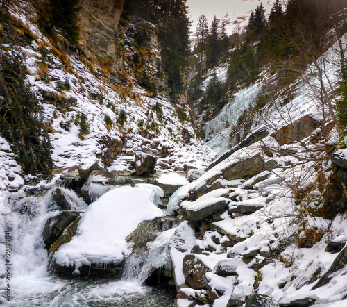 winter wonderland landscape of frozen ice and river in deep winter in the Alps photo