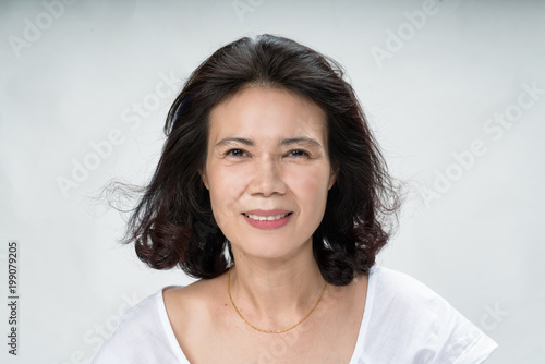 Obraz na plátně Portrait of beautiful mature asian woman with curly hair style smiling with joyful and charming on white background isolate