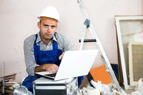Repairer man looking at the laptop informatoin