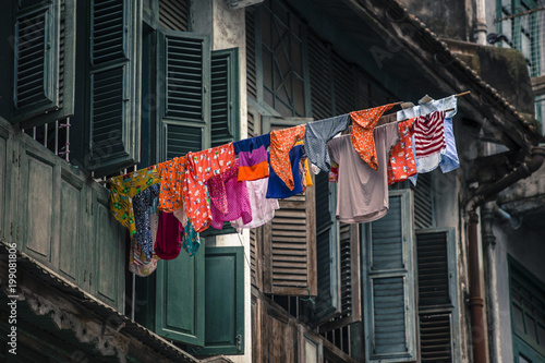 Laundry hanging outside of Old colonial window wooden architecture in Yangon Myanmar Burma South East Asia.