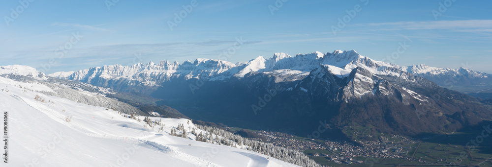 wonderful view of green valley and white mountain landscape in the Swiss Alps in deep winter