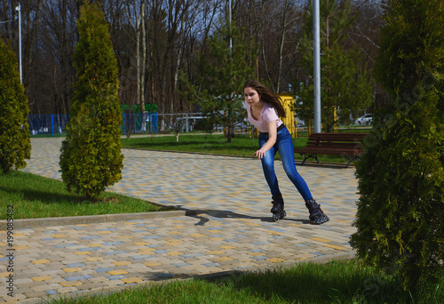 Young beautiful girl with dark hair riding on the rollers