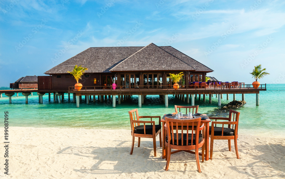 Colorful restaurant at the background of water bungalows in tropical Maldives island