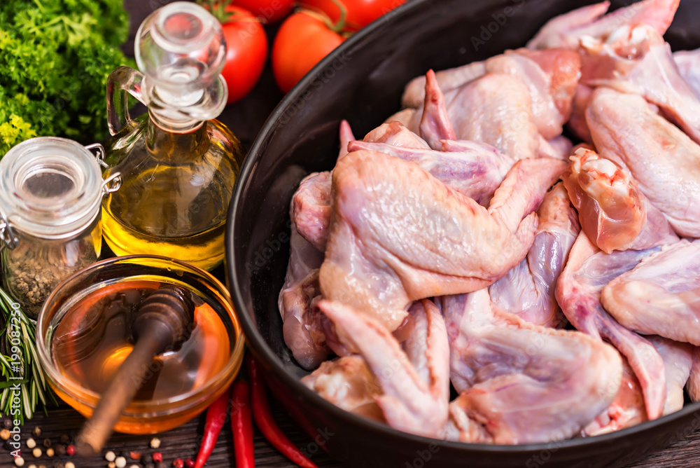 Raw chickens wings, honey, vegetables and spices Raw chickens wings, honey, vegetables and spices