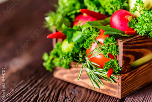 Fresh vegetables and herbs in wooden box