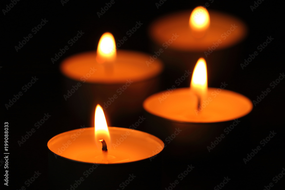 Many candle flames glowing in the dark. Many candle flames glowing in the dark.