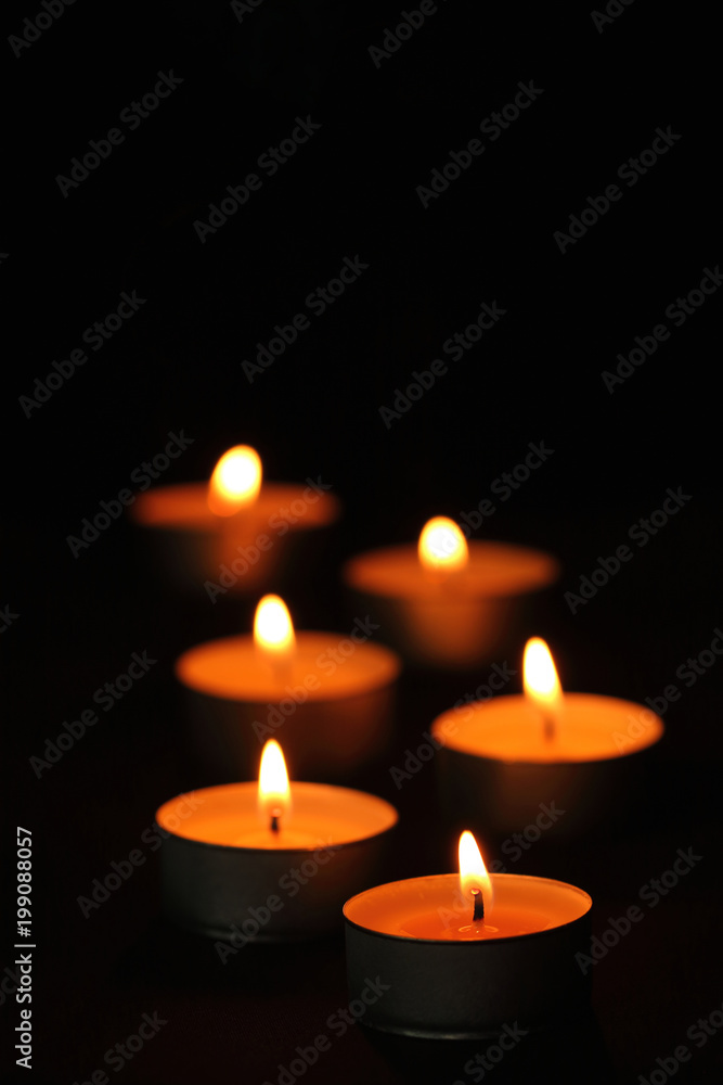 Many candle flames glowing in the dark. Many candle flames glowing in the dark.