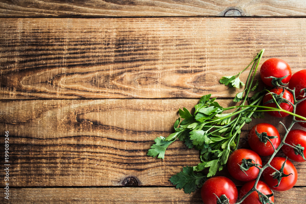 tomatoes with greens on wooden background tomatoes with greens on wooden background