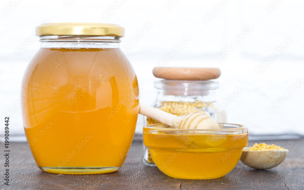 Honey with wooden honey dipper on wooden table Honey with wooden honey dipper on wooden table