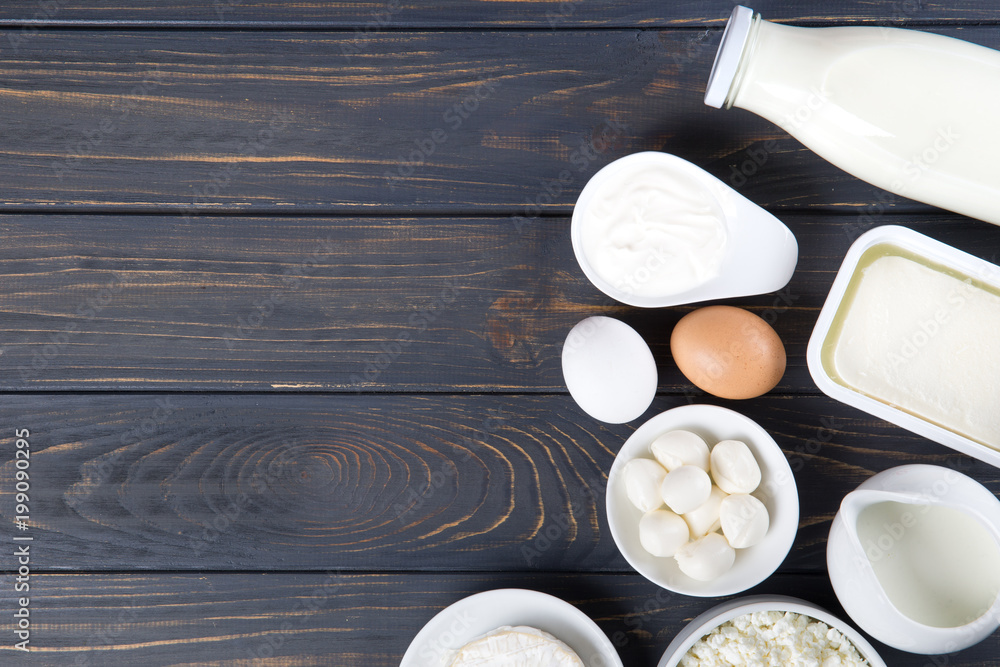 Dairy products on wooden table. Milk, cheese, egg, curd cheese and butter. - obrazy, fototapety, plakaty 