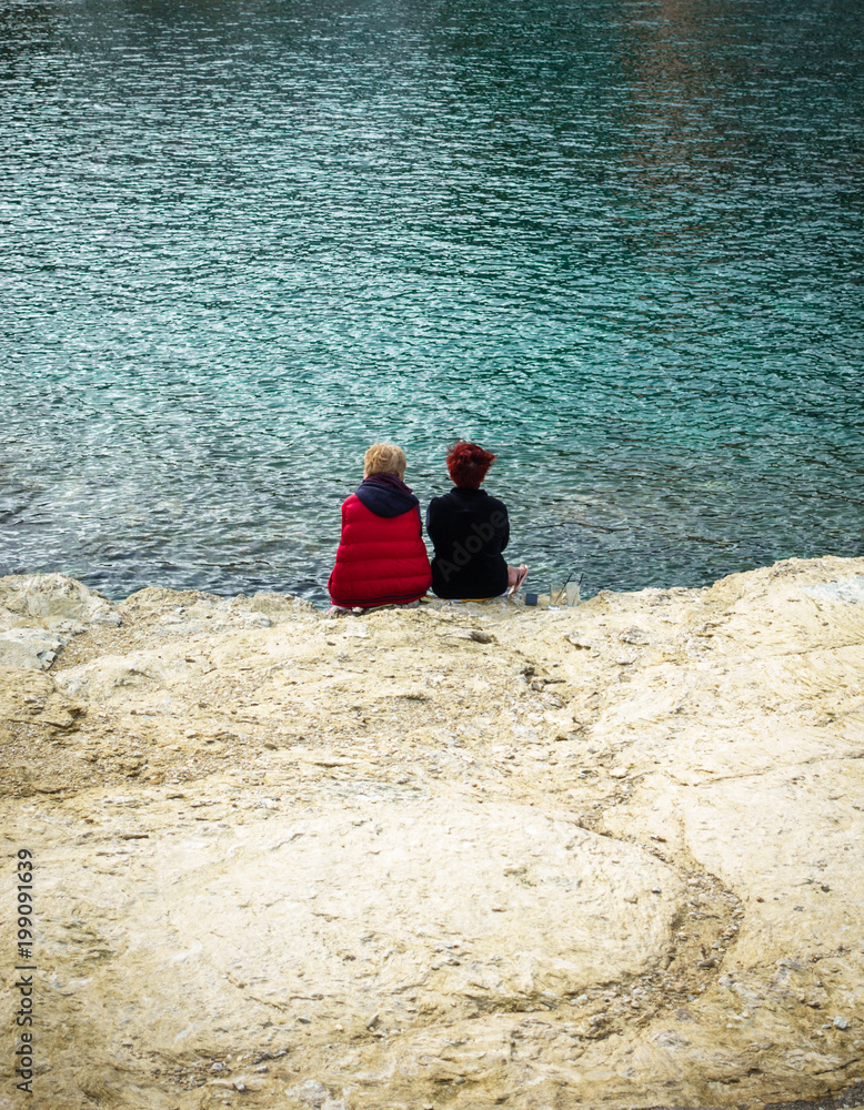 Two kids sitting by the coastline, Greece