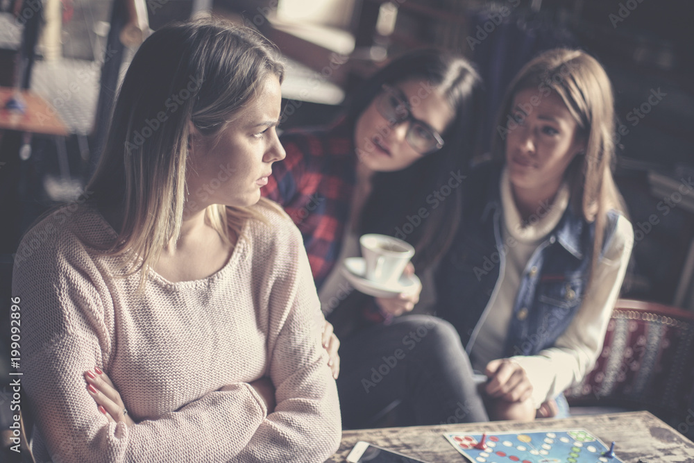 Fototapeta premium Girls playing board game at home and having serious conversation. Close up.
