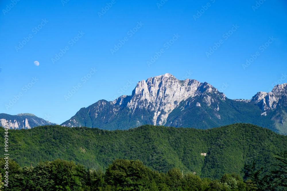 high craggy mountains with rising moon and blue sky in Bosnia and Herzegovina