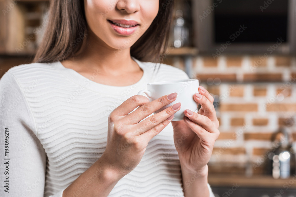 cropped shot of young african american woman holding cup of coffee cropped shot of young african american woman holding cup of coffee
