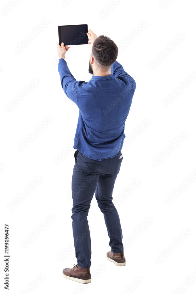 Rear back view of elegant handsome business man taking selfie photo with tablet. Full body isolated on white background. Rear back view of elegant handsome business man taking selfie photo with tablet. Full body isolated on white background.