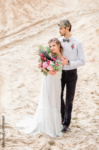 The bride and groom on the sand. Beautiful wedding ceremony.