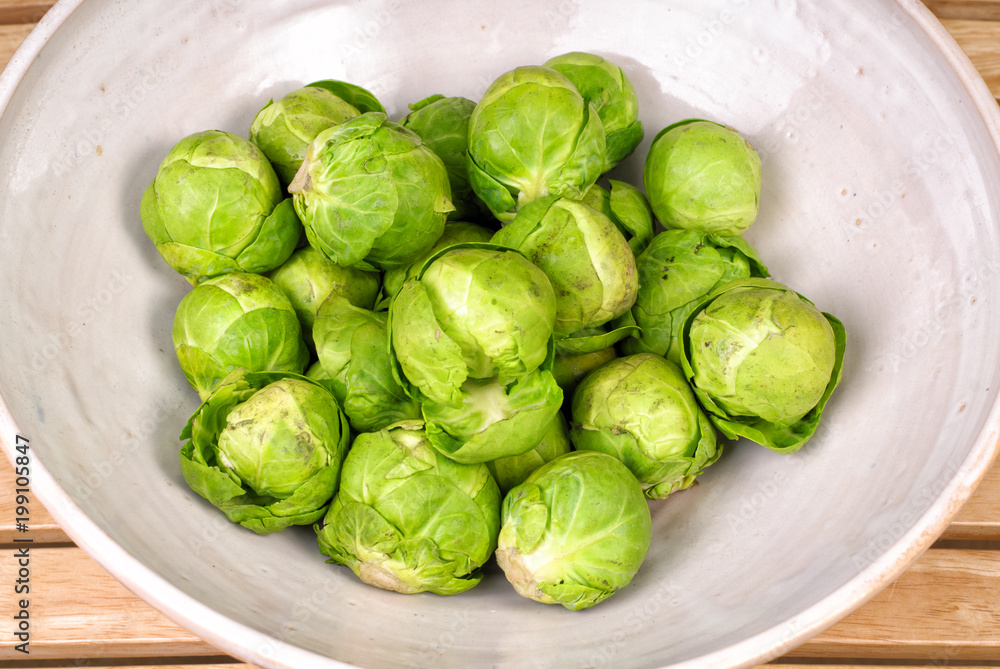 Fresh raw rustic brussels sprouts in a ceramic bowl Fresh raw rustic brussels sprouts in a ceramic bowl