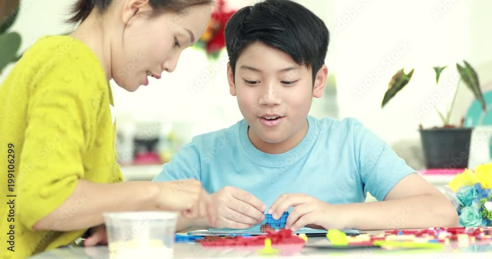 Happy asian family mother and son playing plastic block together . Happy asian family mother and son playing plastic block together .