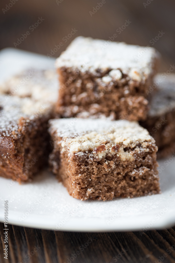 Brownie stack, closeup chocolate cake in white plate on rustic wooden table