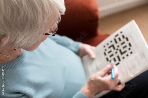 Obraz na płótnie Senior Woman Doing Crossword Puzzle At Home