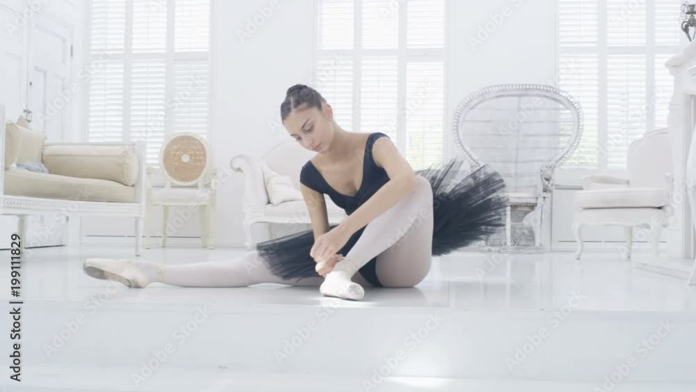Graceful ballerina practicing ballet in white studio, slow motion Graceful ballerina practicing ballet in white studio, slow motion