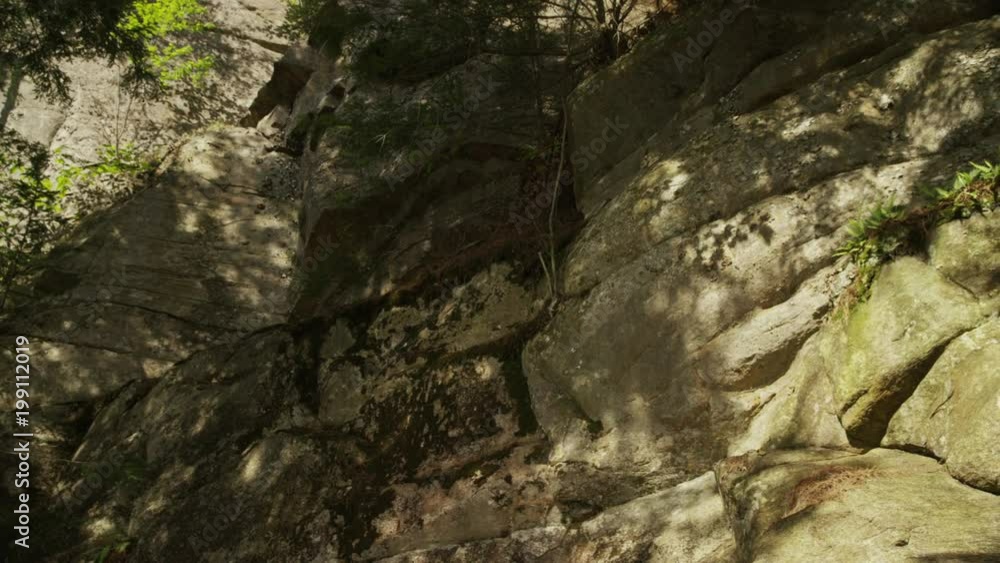 Slow Pan Across Rocky Cliff with Water Reflection Slow Pan Across Rocky Cliff with Water Reflection