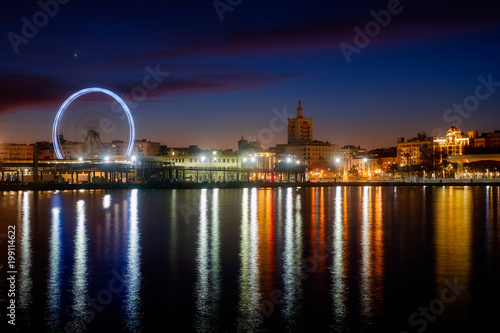 View of Malaga city and Ferris wheel from harbour, Malaga, Spain, long exposure