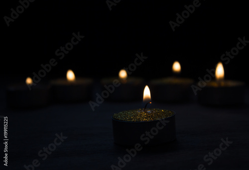 Burning candles on the dark wooden table 