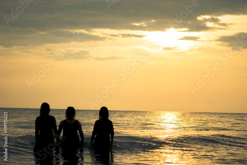 silhouette happy three woman on the sunset beach © apichart609