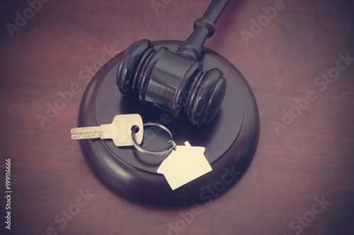 Real estate court decision concept, judge gavel and key with key holder on table