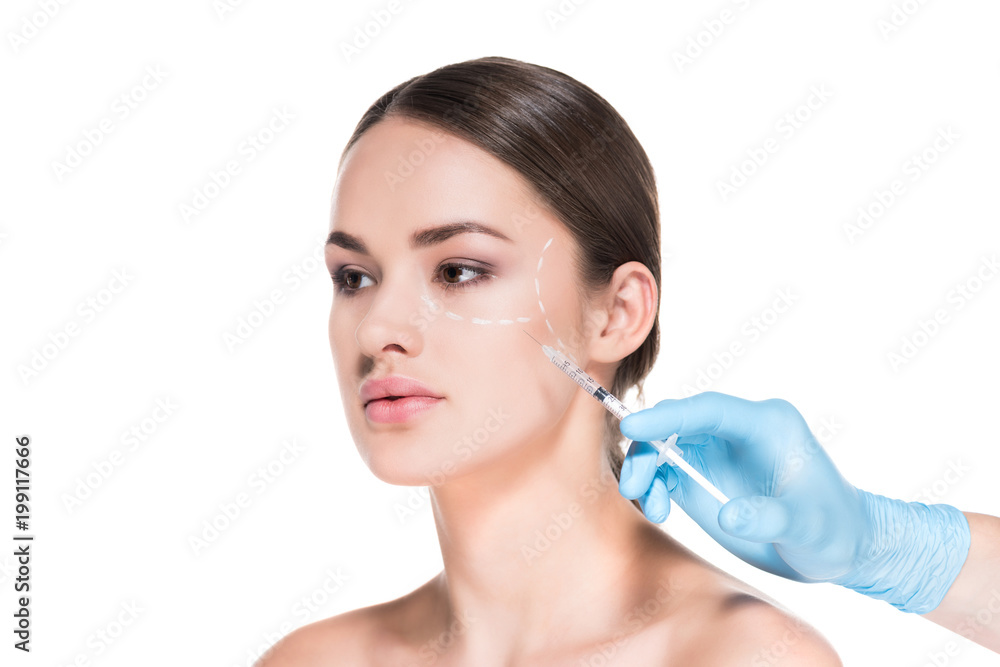 cropped shot of doctor making beauty injection for young woman while she looking away isolated on white cropped shot of doctor making beauty injection for young woman while she looking away isolated on white