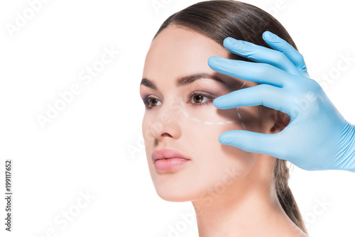 doctor touching face of young woman with dotted line for plastic surgery isolated on white